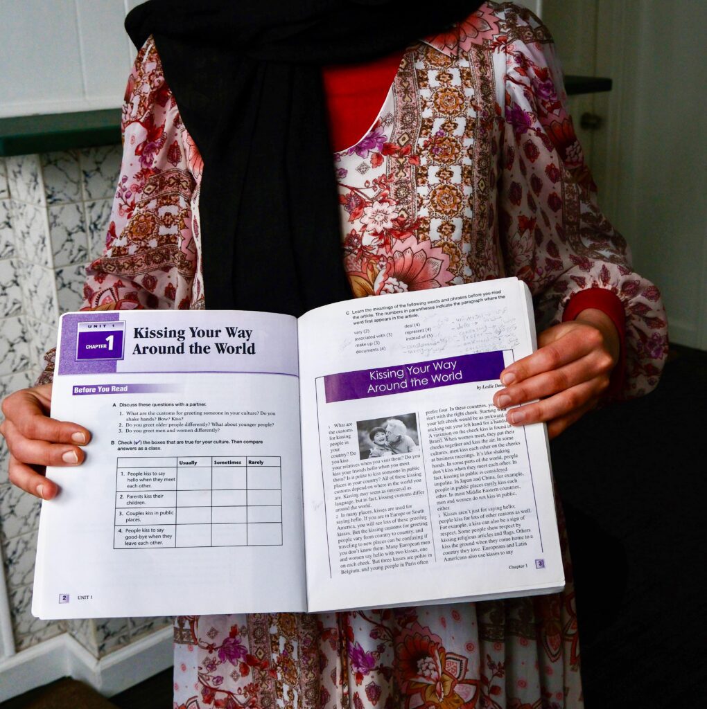 Jamila displays a literacy book she uses to hone her English skills. (Photo by Tracy Certo)