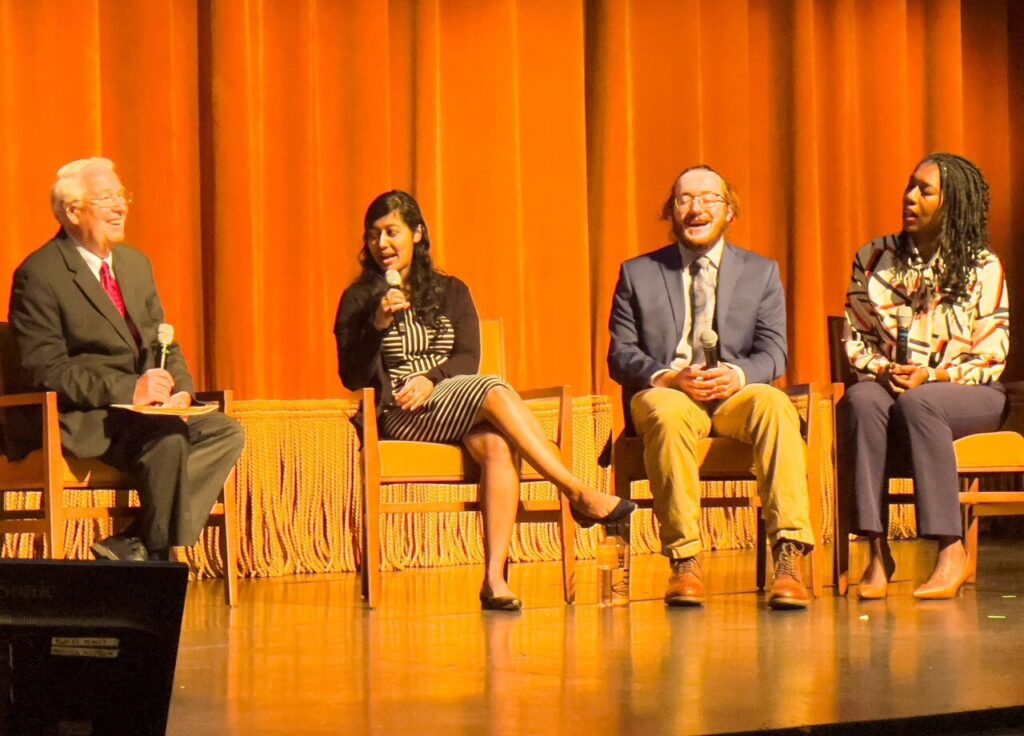 Annafi Wahed seated in the center of a panel discussion on a stage.