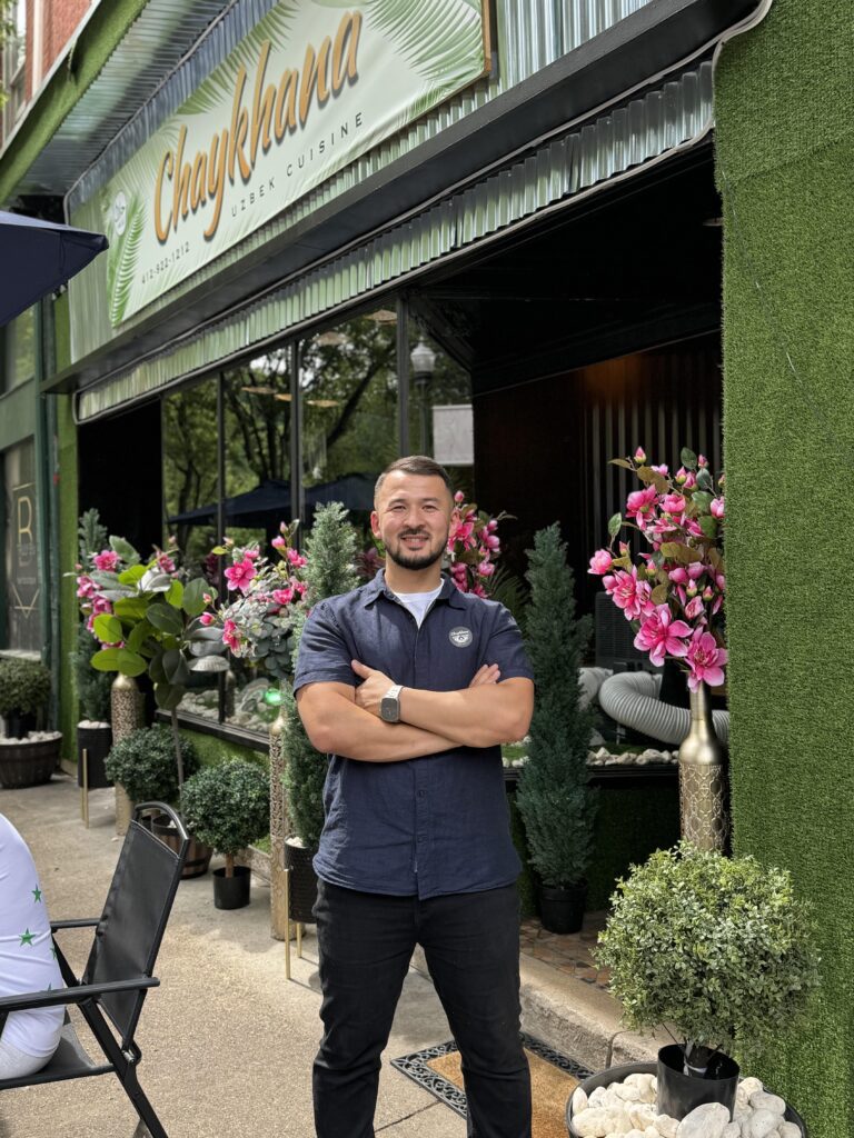 Owner Sarver Abdurashidov stands outside another of his restaurants, Chaykhana, in the Pittsburgh’s West End. He stands flower surrounding him with crossed arms.