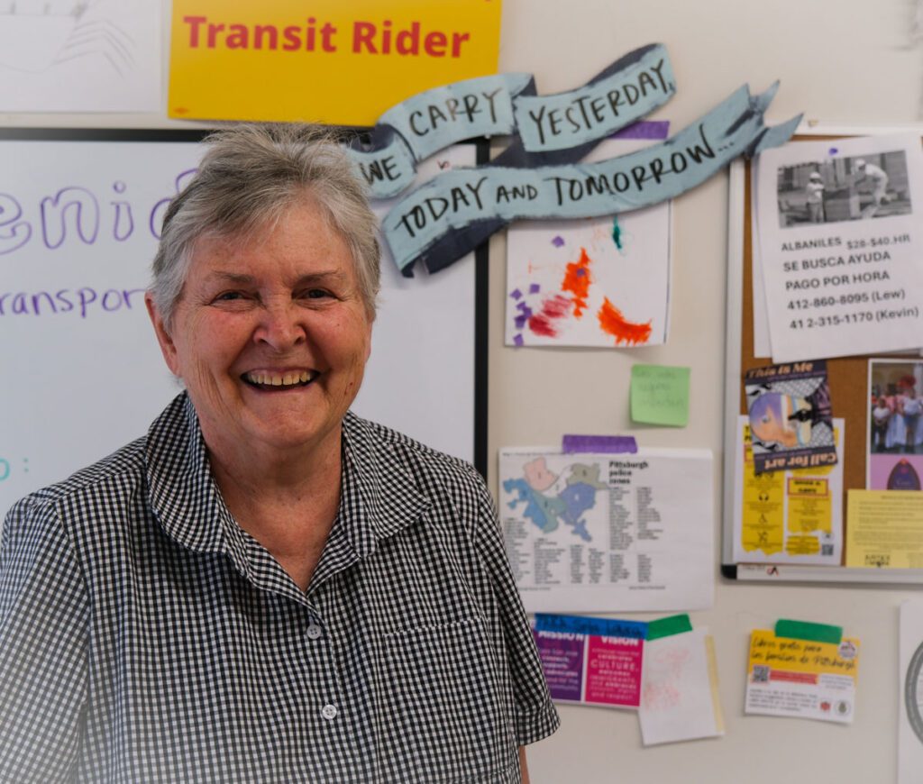 Sister Janice pictured in front of a community board at Casa San Jose