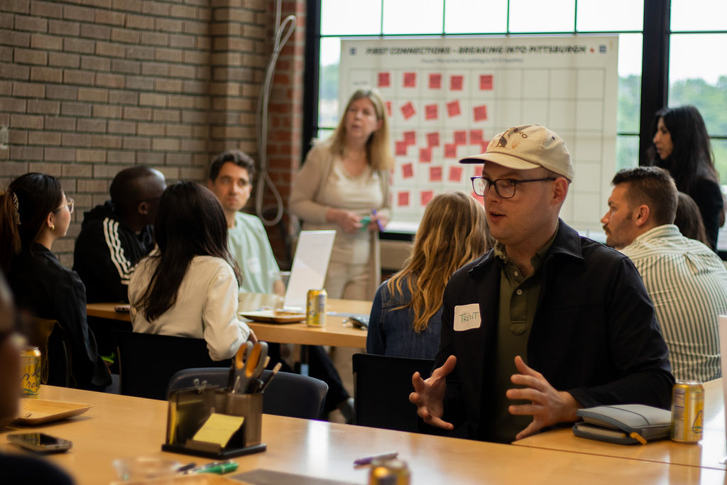 A man gestures while brainstorming in a full room